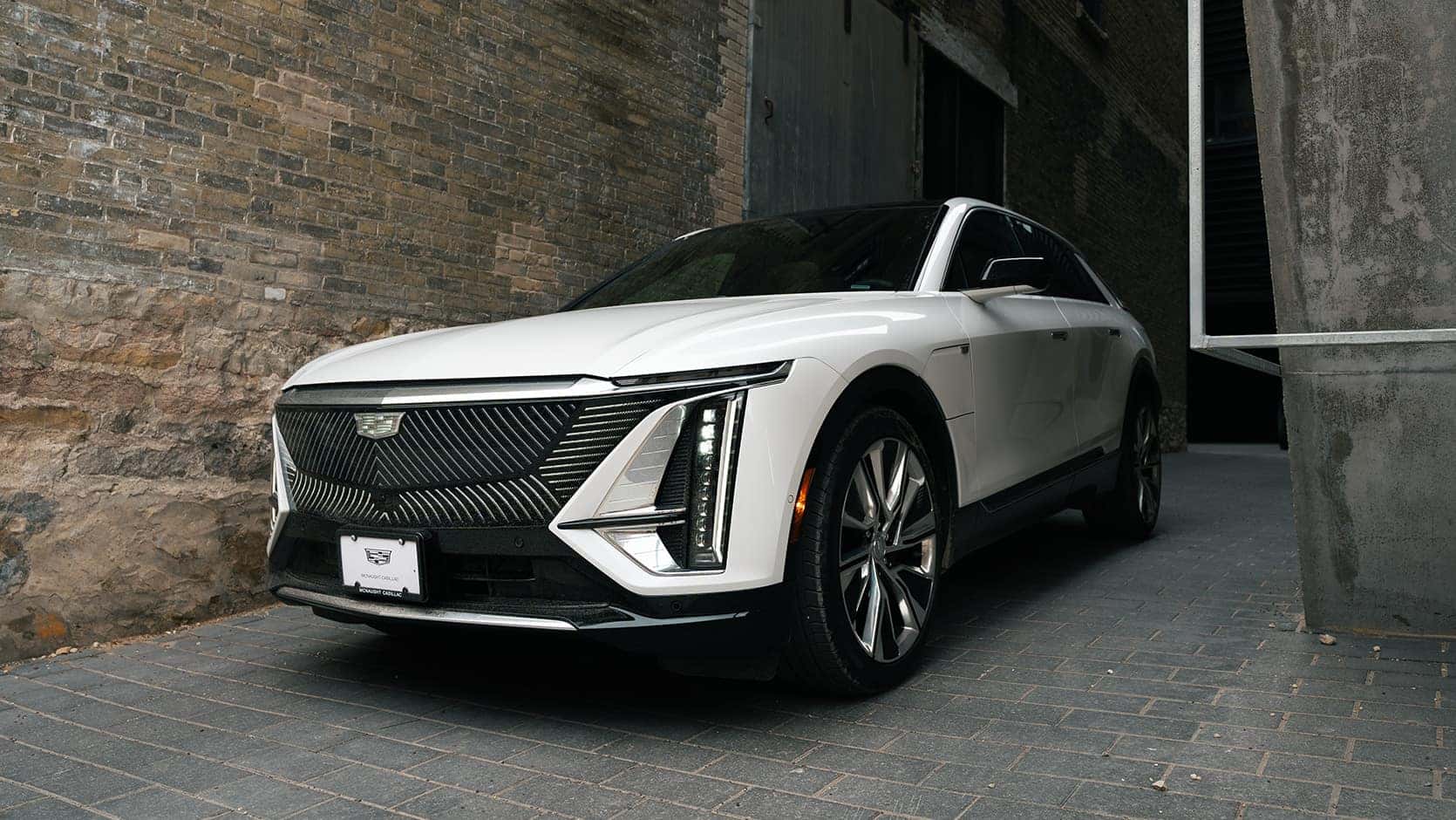 Sleek white luxury SUV parked in alley, showcasing modern design and futuristic styling.