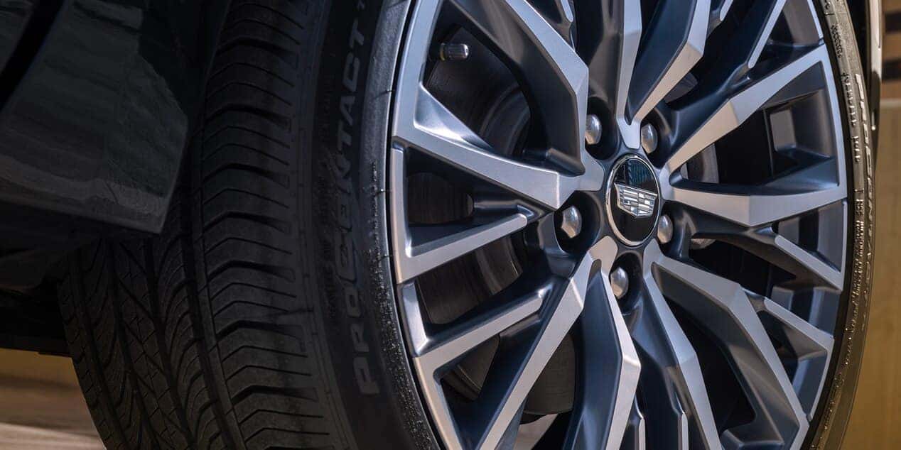 Close-up of a Cadillac wheel with intricate alloy rim design and visible tire tread.