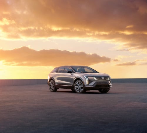 Sleek SUV parked under a vibrant sunset sky, highlighting its modern design and elegance.
