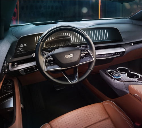 Luxury car interior with digital dashboard, steering wheel, and brown leather seats.